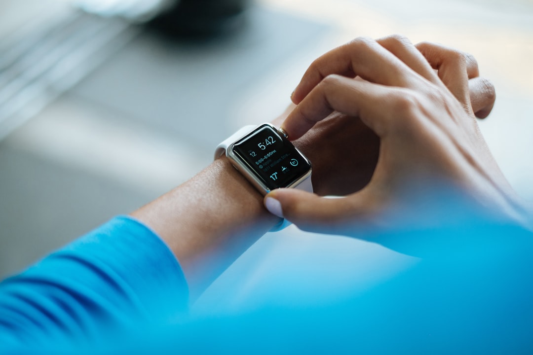 Person tapping a smart watch to check fitness tracking