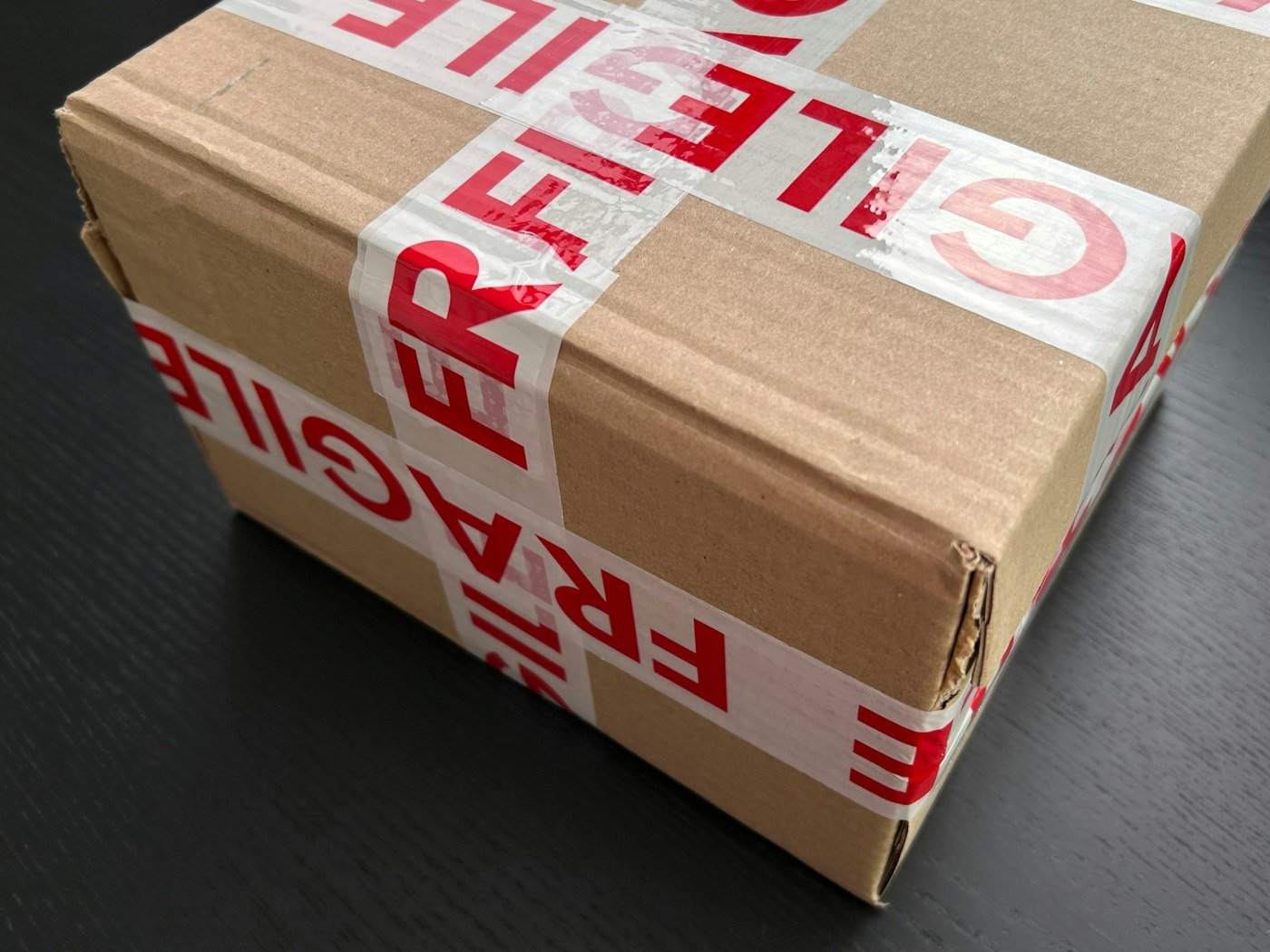 Damaged cardboard parcel being photographed for a dispute